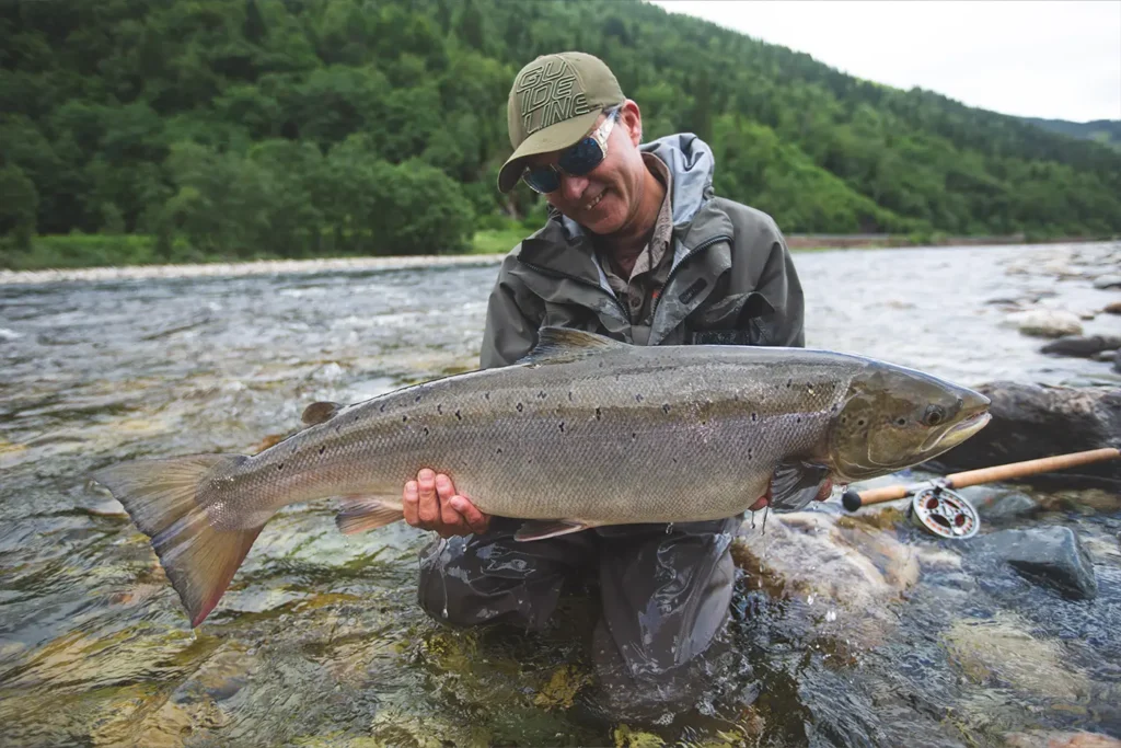 A man showcasing a sizable fish while fishing in the river using Gaula techniques.