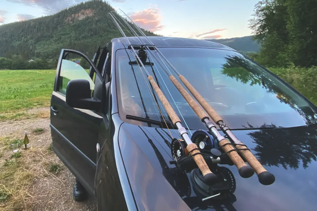 A black car equipped with fishing rods protruding from the hood, showcasing expert Gaula fishing tips.