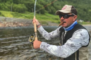 A man is fishing on a river with a fly rod, utilizing Gaula fishing tips.