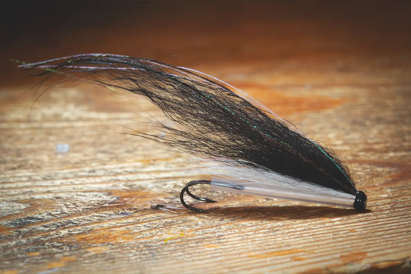 A classic black and white fly on a wooden surface.