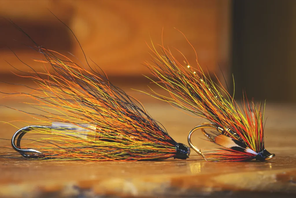 Two classic Gaula flies buzz on a wooden table.