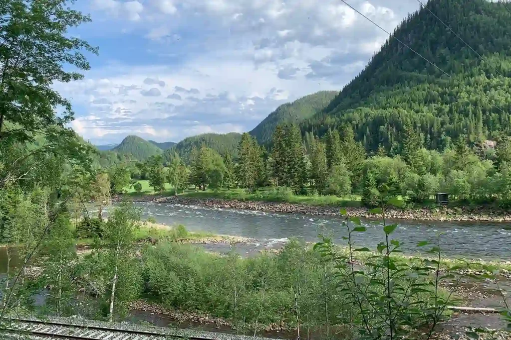 A view of a river and mountains from a train track.
