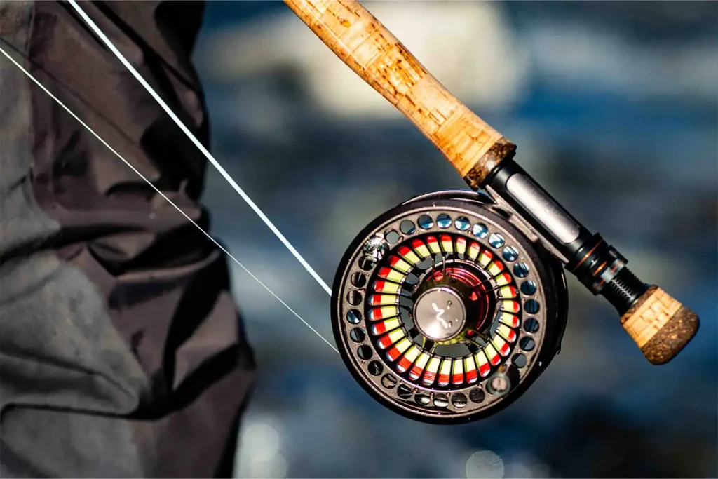 A person holding a fly fishing rod and reel.